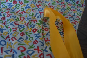 I stitched ribbon into the side seam so the letter learning bag can be tied closed.